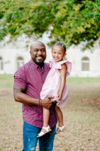 Dad holds toddler daughter a models what to wear for spring family photography